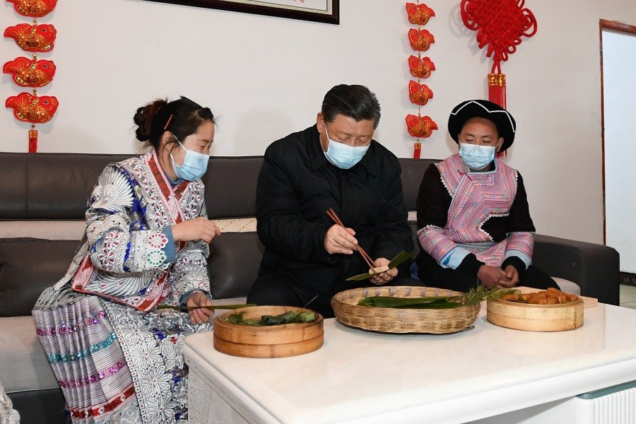 2021年2月3日下午，習(xí)近平在貴州畢節(jié)市黔西縣新仁苗族鄉(xiāng)化屋村苗族村民趙玉學(xué)家，同一家人邊聊家常邊制作當(dāng)?shù)貍鹘y(tǒng)節(jié)日食品黃粑。新華社記者 李學(xué)仁 攝