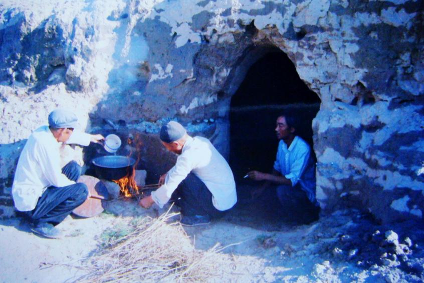 1983年，“六老漢”一代治沙人在“地窩子”生活做飯。新華社發(fā)（八步沙林場供圖）